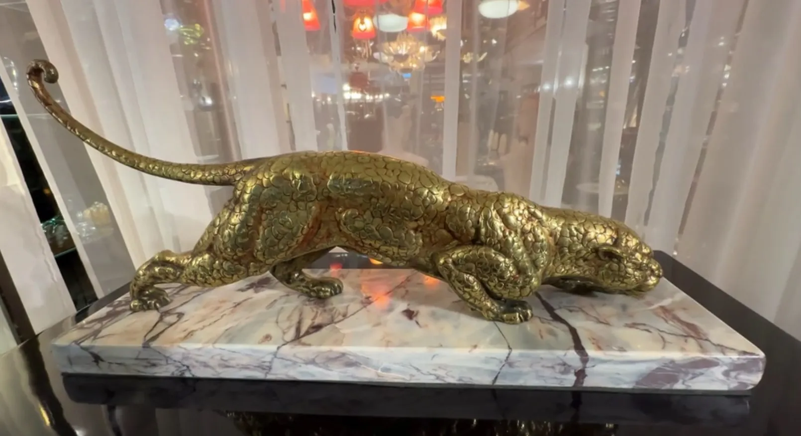 escultura antigua de felino con base decorativa