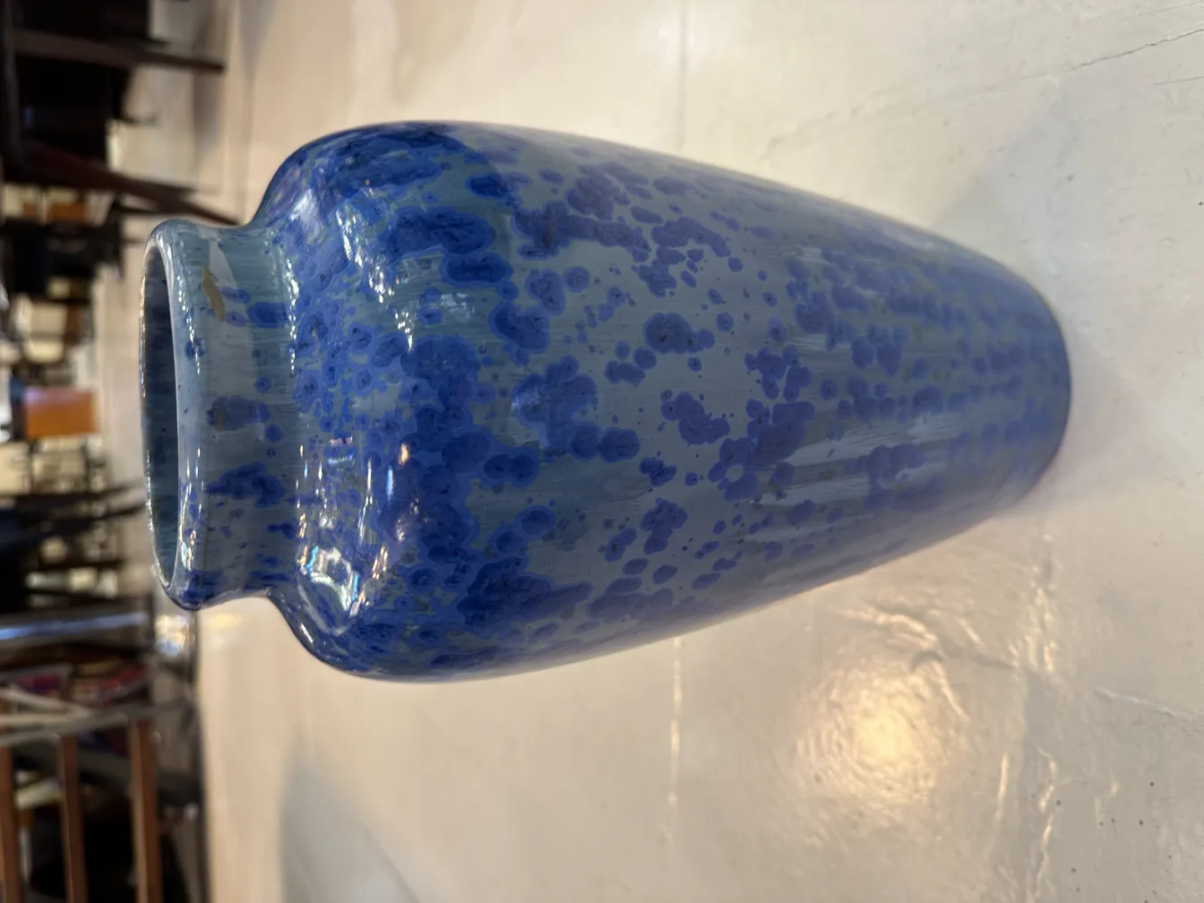 Antica ceramica blu con macchie su uno sfondo lucido.