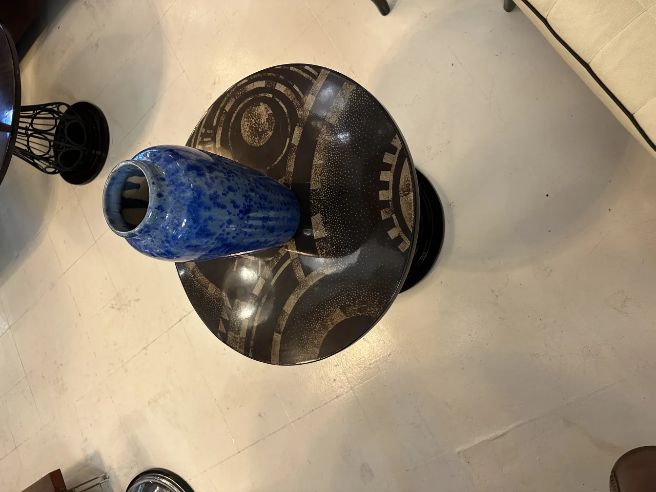 Vaso decorativo antigo de cerâmica azul sobre mesa.