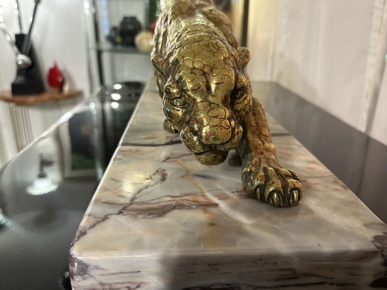 scultura di pantera con dettagli dorati su base in marmo