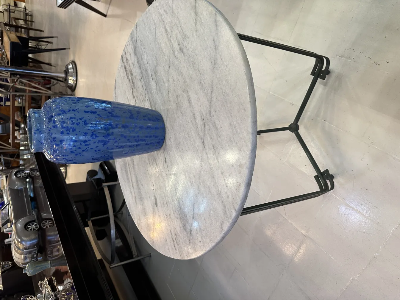 Vase ancien en céramique bleue de forme allongée, fond clair.