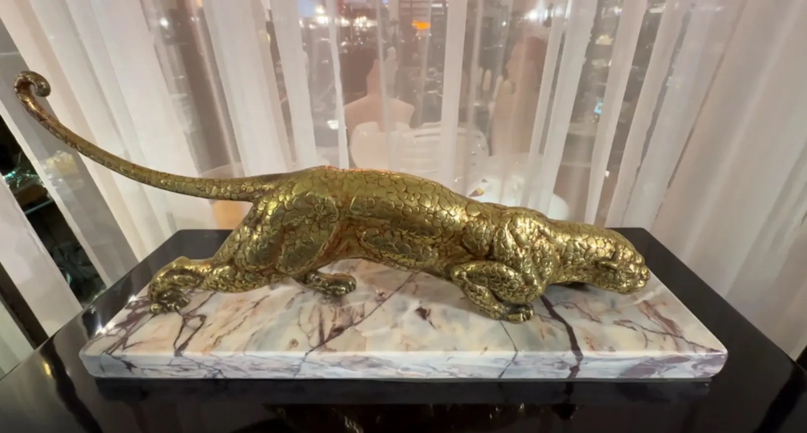 escultura de un gato en una base de mármol, pose elegante