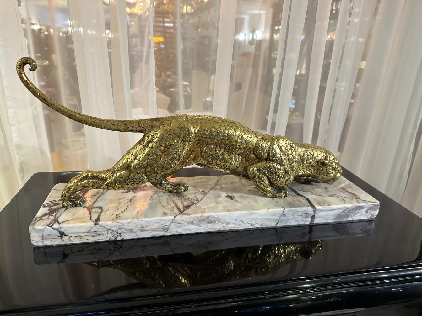 Antique sculpture of an animal in motion on a marbled base