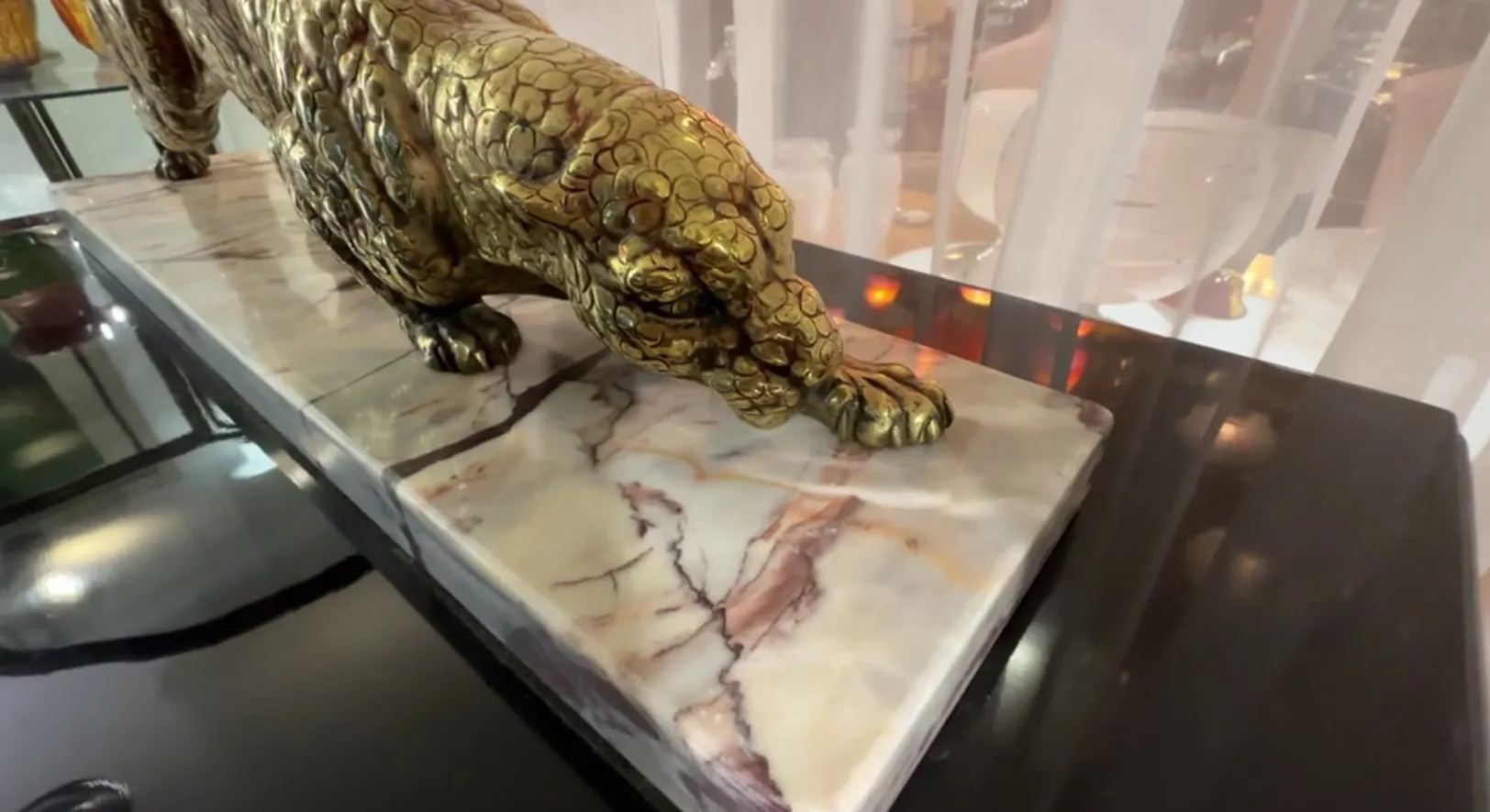 escultura antiga de um felino, colocada sobre uma base