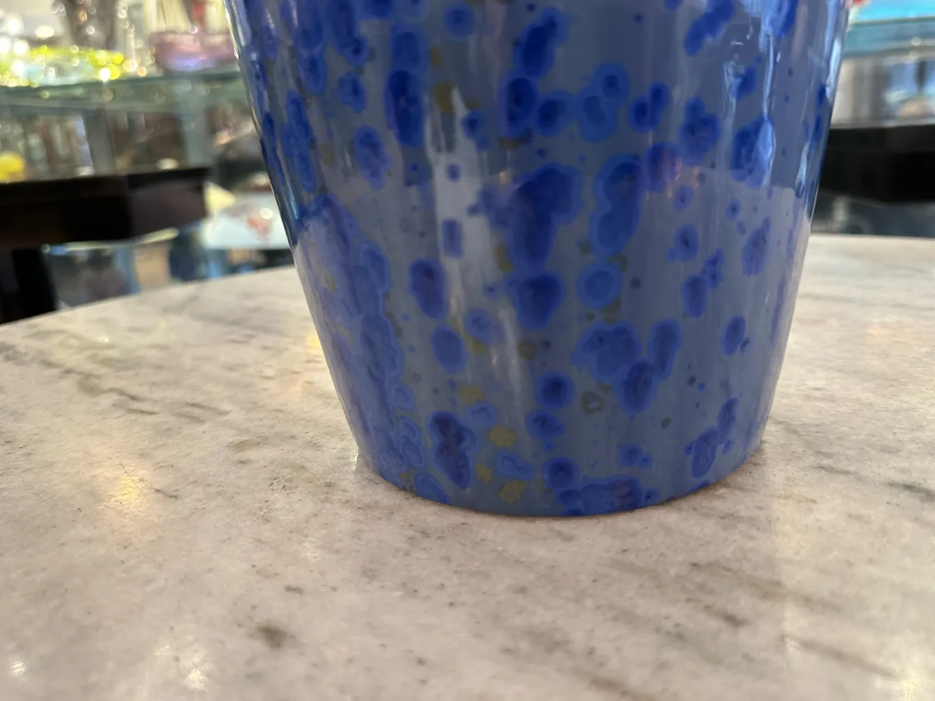 Taza de cerámica antigua en azul con patrones.