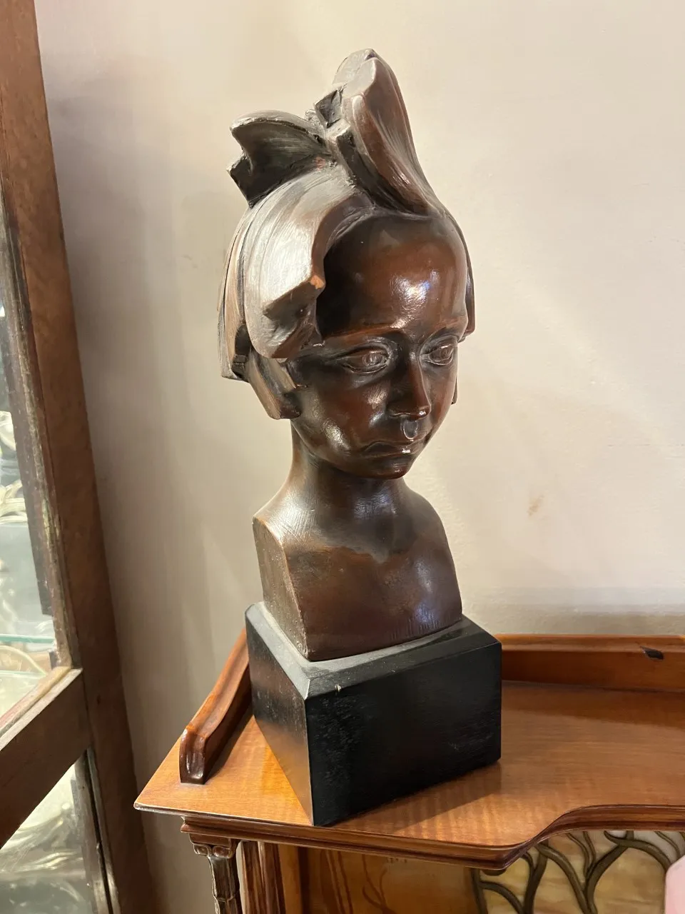 Escultura antigua de retrato con detalles realistas, ambiente acogedor.