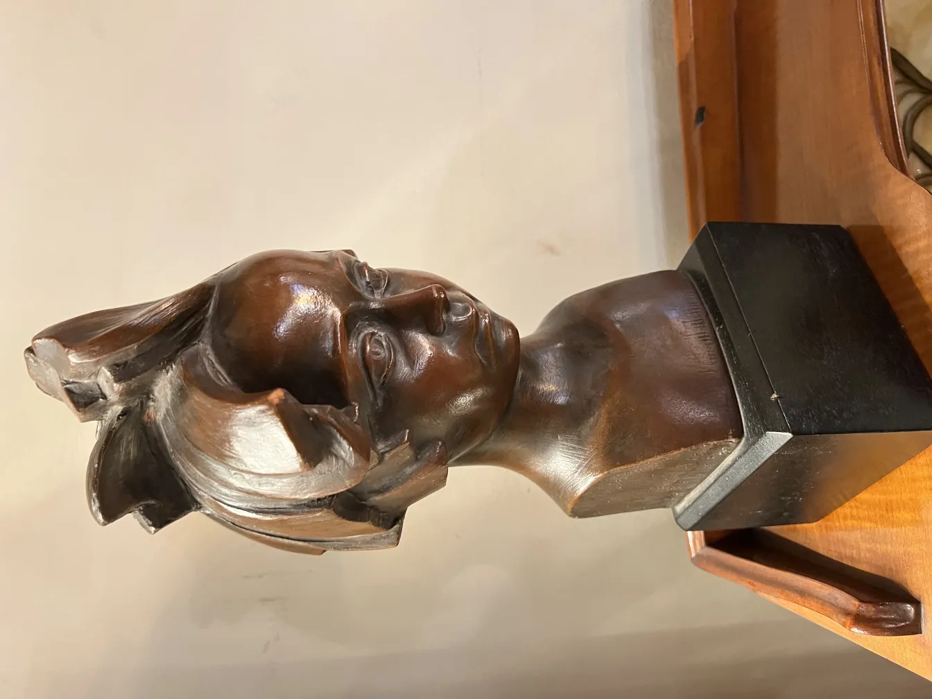 scultura antica di busto con dettagli facciali chiari e sfondo neutro