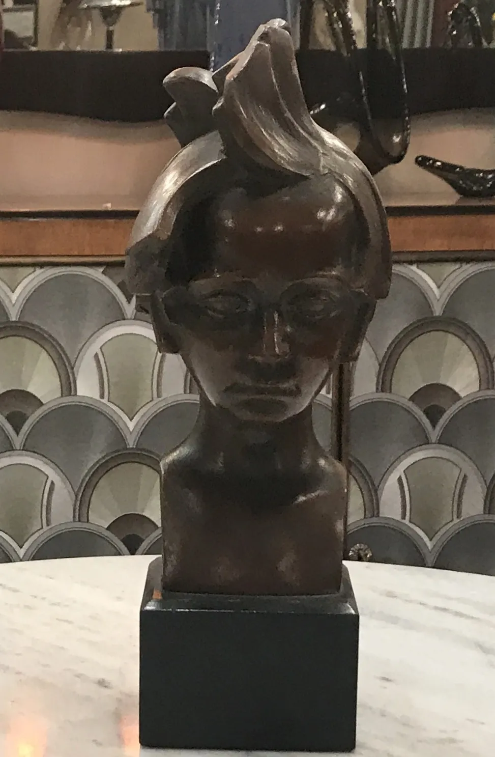 antique sculpture of human figure with serious expression, decorated background