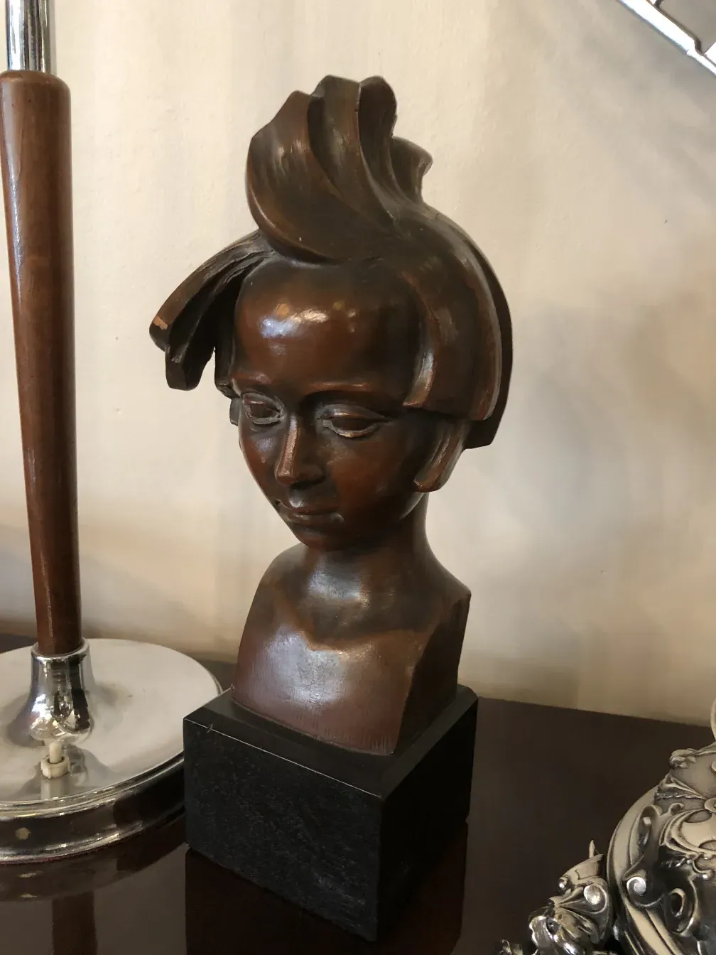 antique sculpture of a human head with unique hairstyle