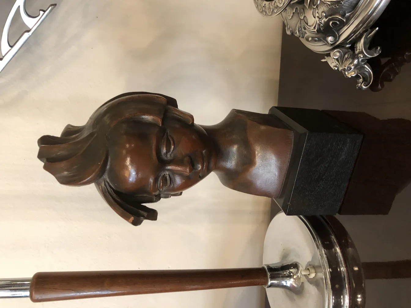 scultura antica in bronzo a forma di testa femminile
