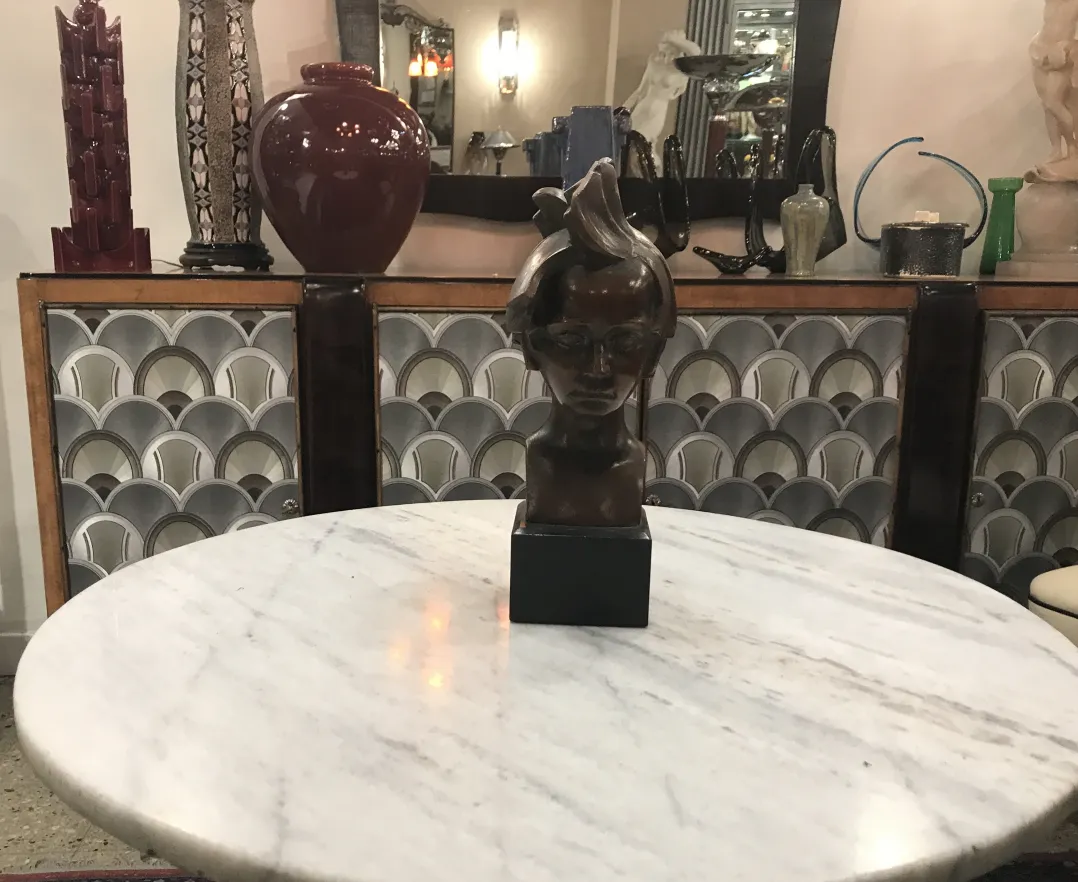 escultura antigua de una cabeza en una mesa