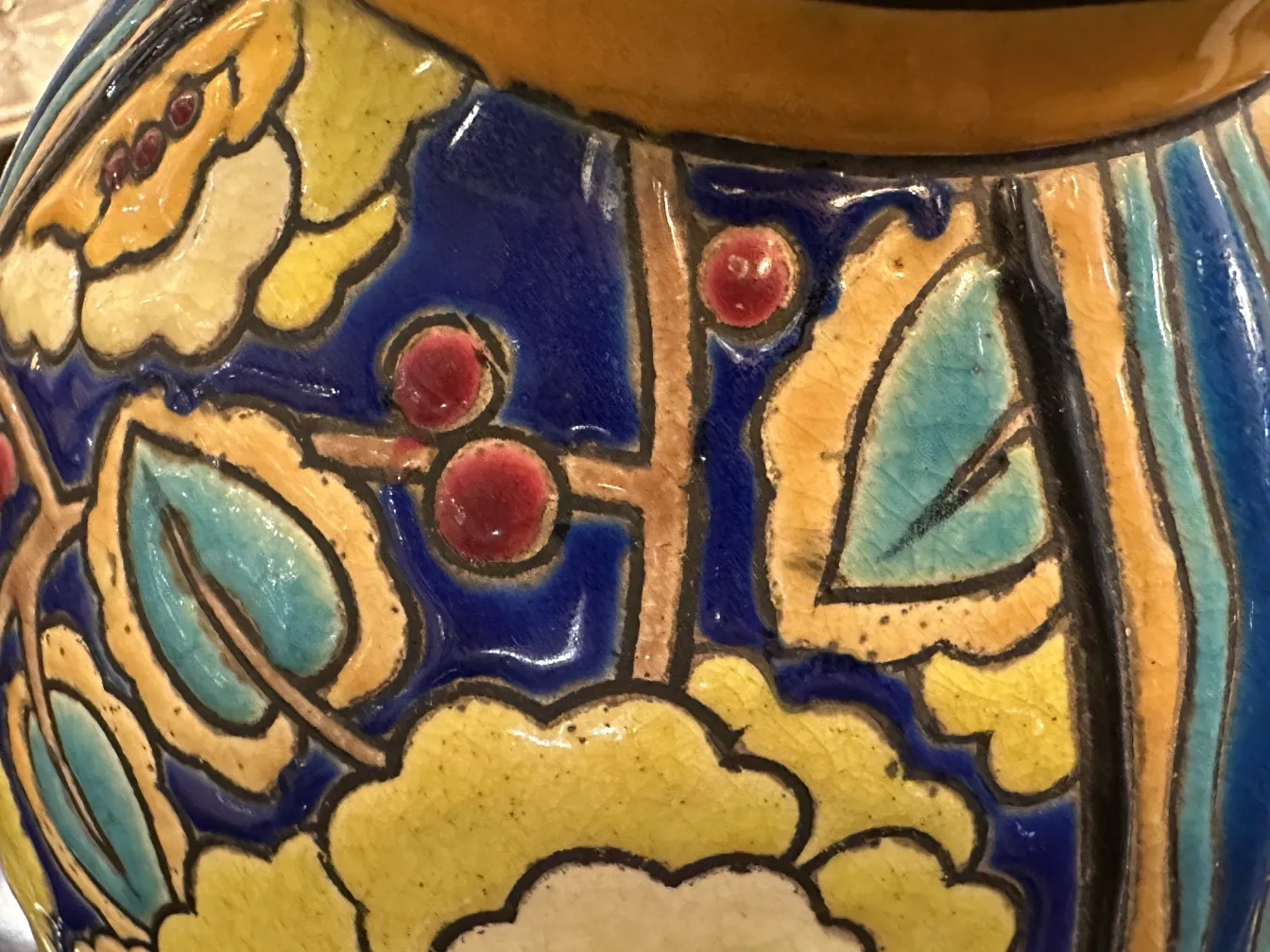 Céramique décorative antique de Boch frères Keramis avec des motifs floraux colorés.