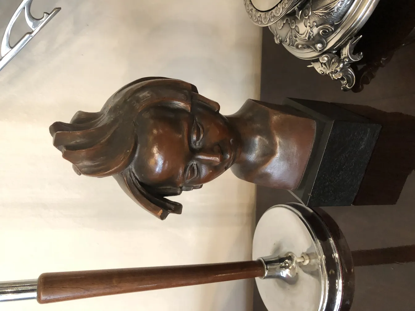 Sculpture antique de tête avec des détails expressifs, fond neutre.