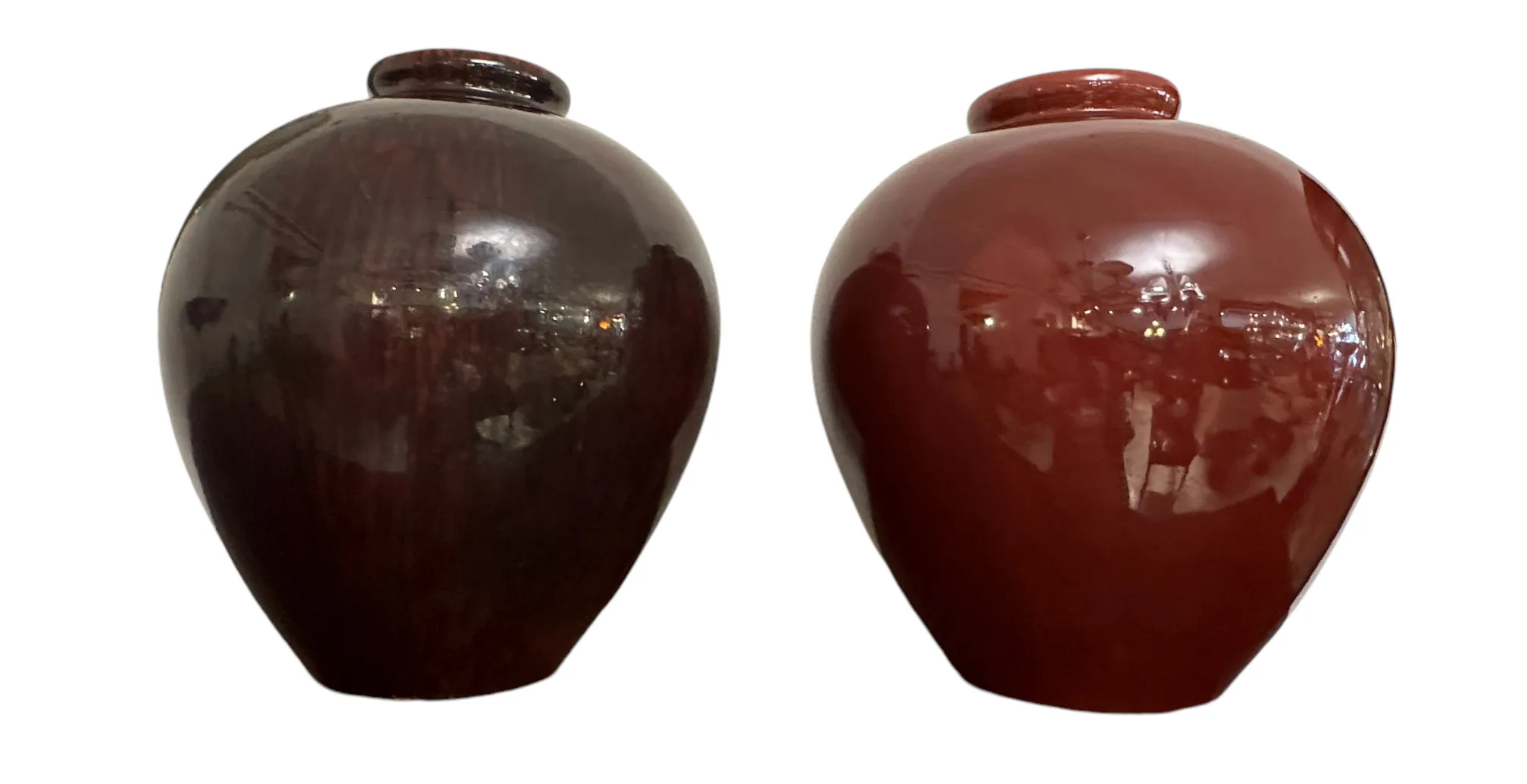 Dois vasos de cerâmica antigos, um marrom e um vermelho.