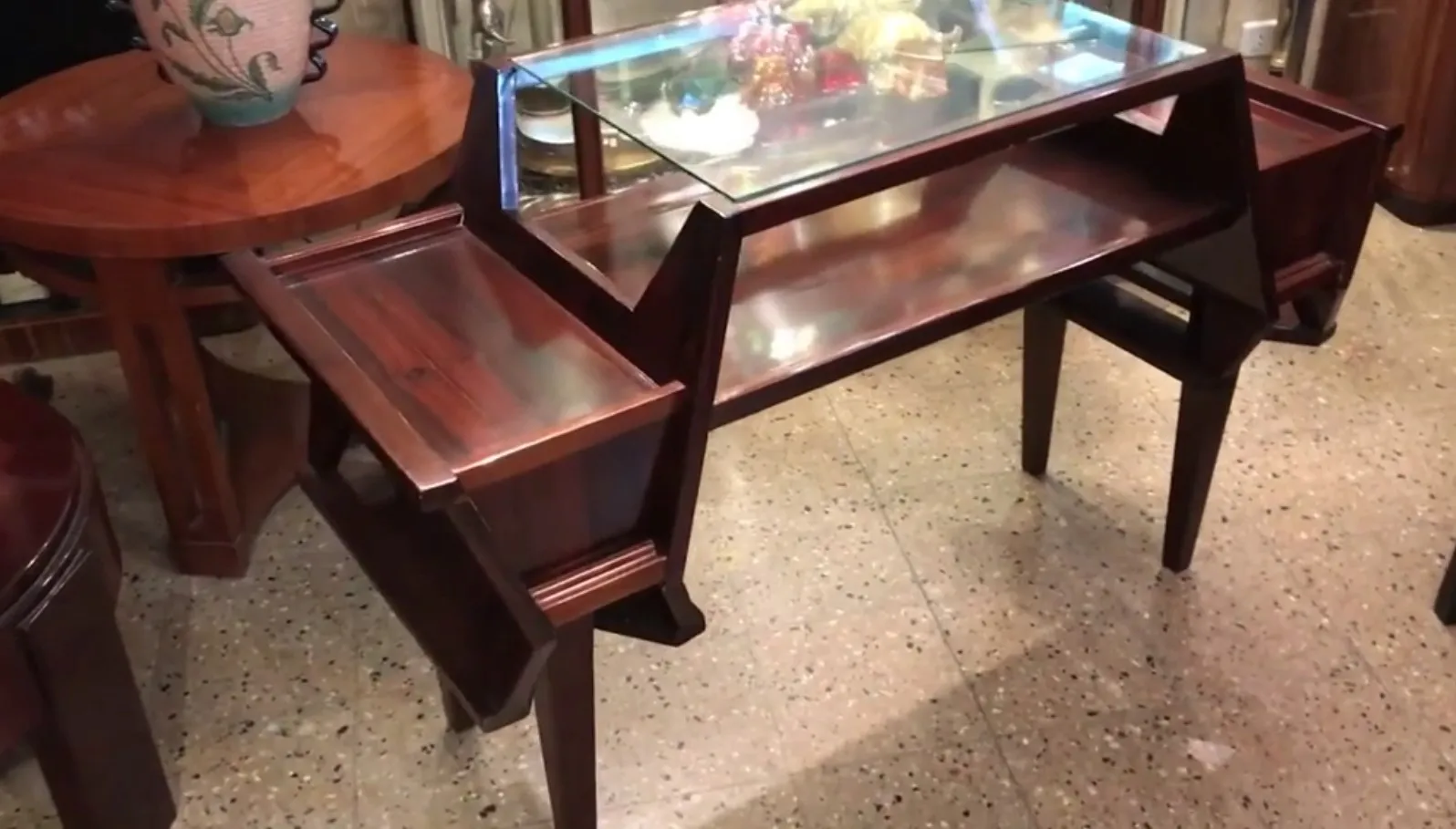 scrivania antica con una finitura lucida, decorata in modo intricato e circondata da mobili classici