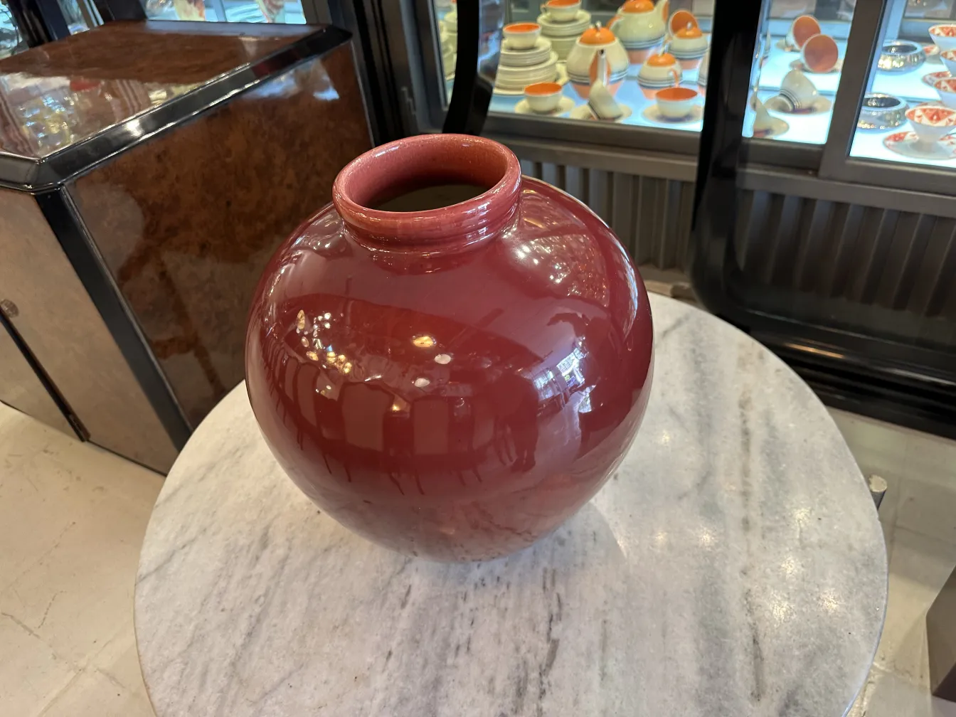 Vaso di ceramica rossa lucida su tavolo in marmo