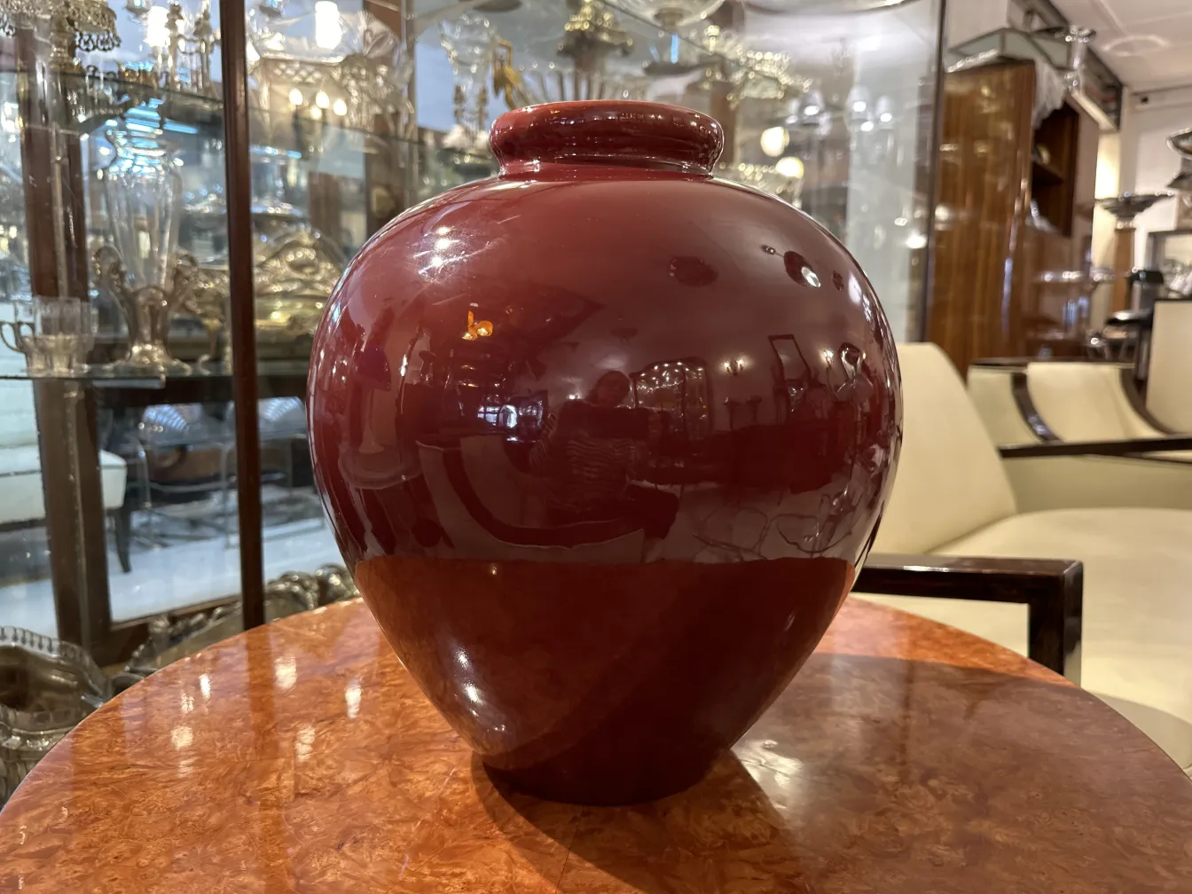 Vaso di ceramica rossa antica e liscia su un tavolo.