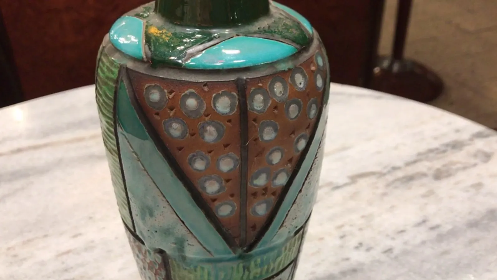 Giara antica di ceramica decorata con tonalità colorate e motivi geometrici.