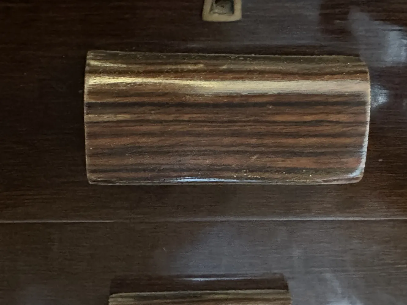 détail d'un bureau ancien avec des poignées élégantes, fond sombre