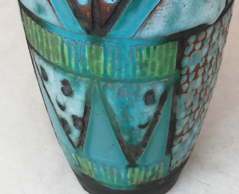 Ceramica antigua decorada en tonos azules y verdes con diseños abstractos.