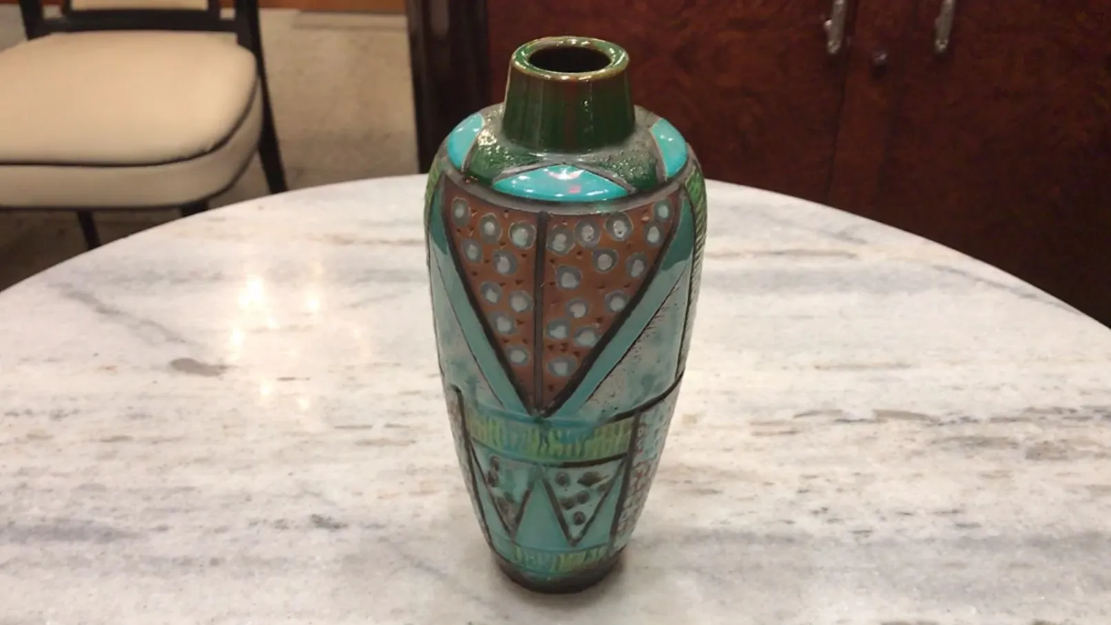 Vase en céramique ancienne colorée avec des motifs géométriques.