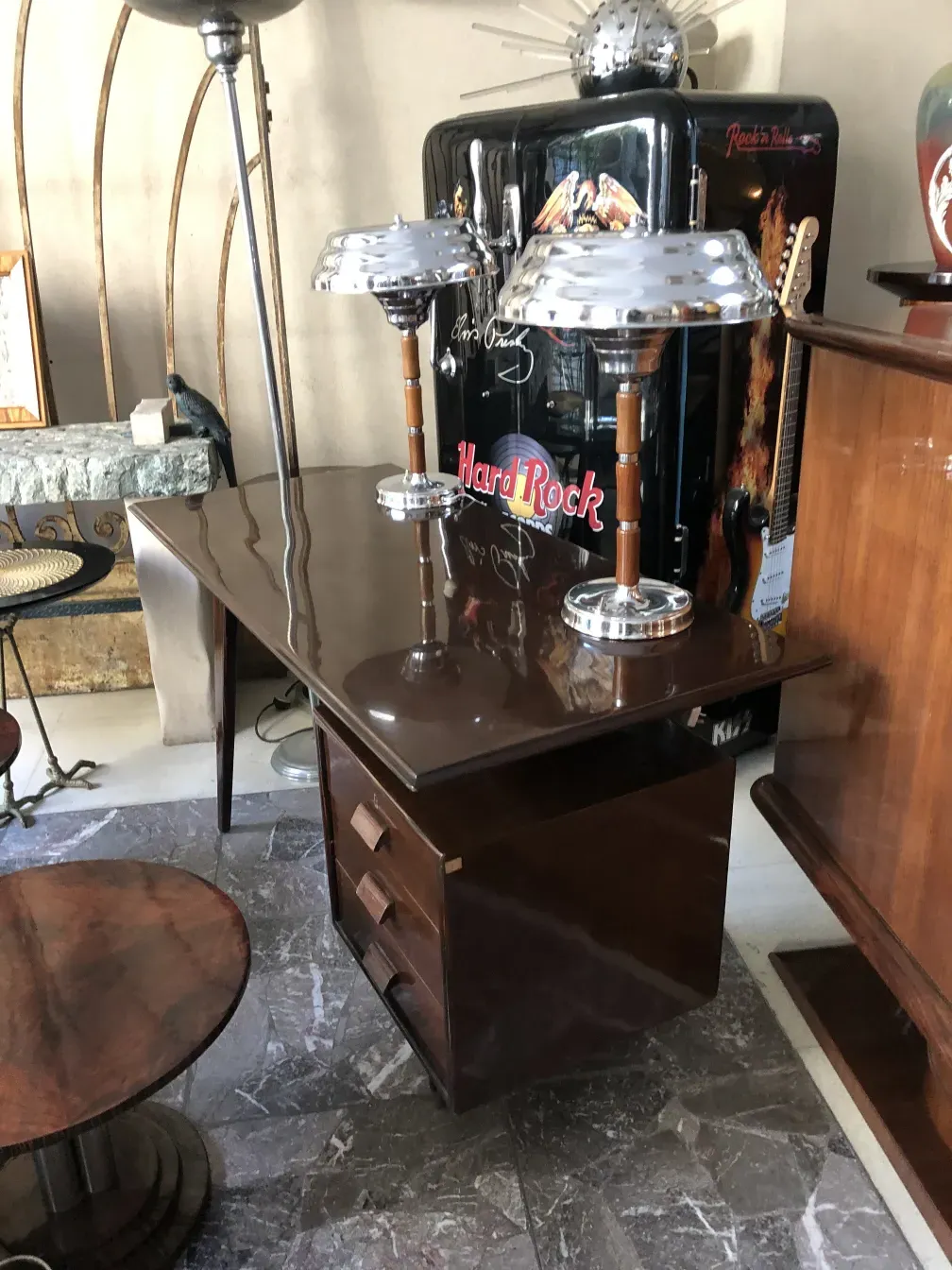 Escritorio antigo com acessórios decorativos em um ambiente elegante, incluindo lâmpada e decoração.