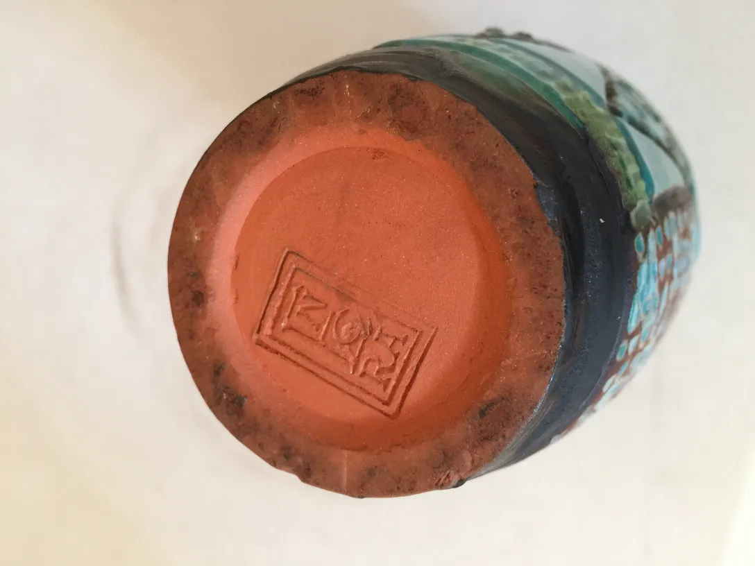 Unterseite eines antiken keramischen Stücks mit buntem Design.