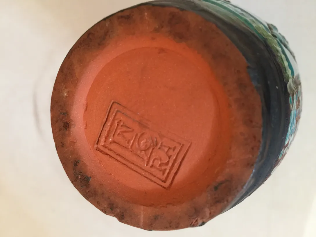 Parte inferiore di una ceramica decorativa antica con incisione.