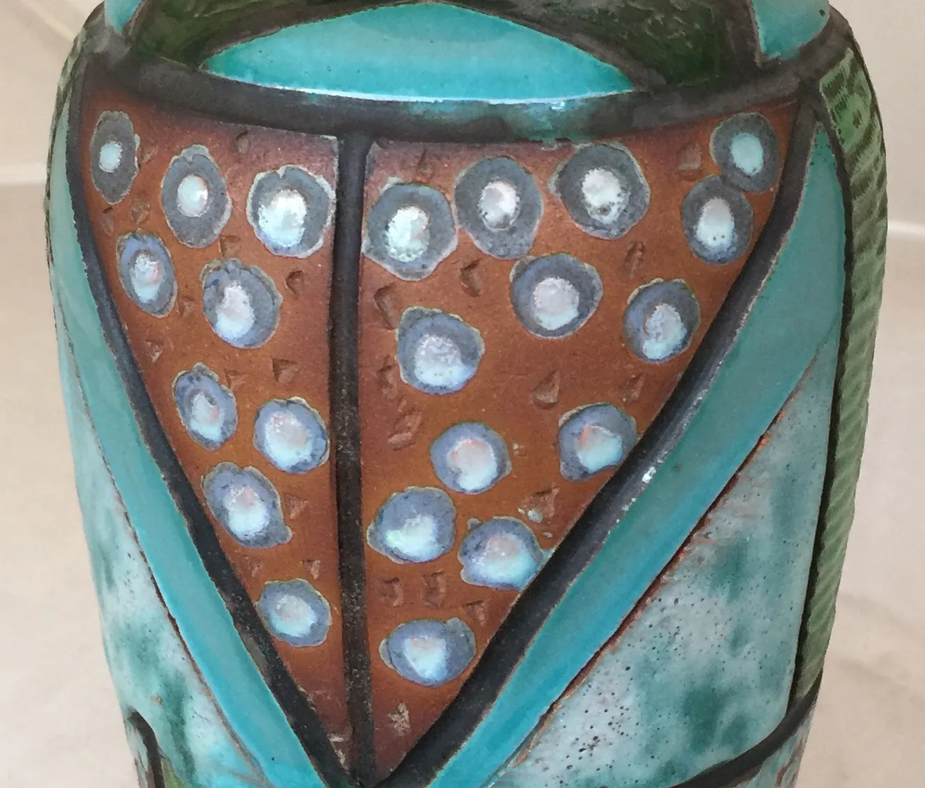 Vaso in ceramica antica con motivi decorativi colorati.