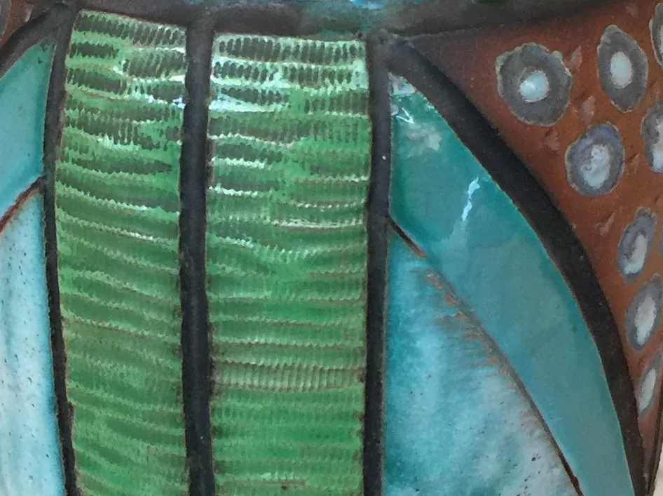 Céramique ancienne décorative en tons de vert et turquoise. Présente des détails stylisés qui complètent la pièce.