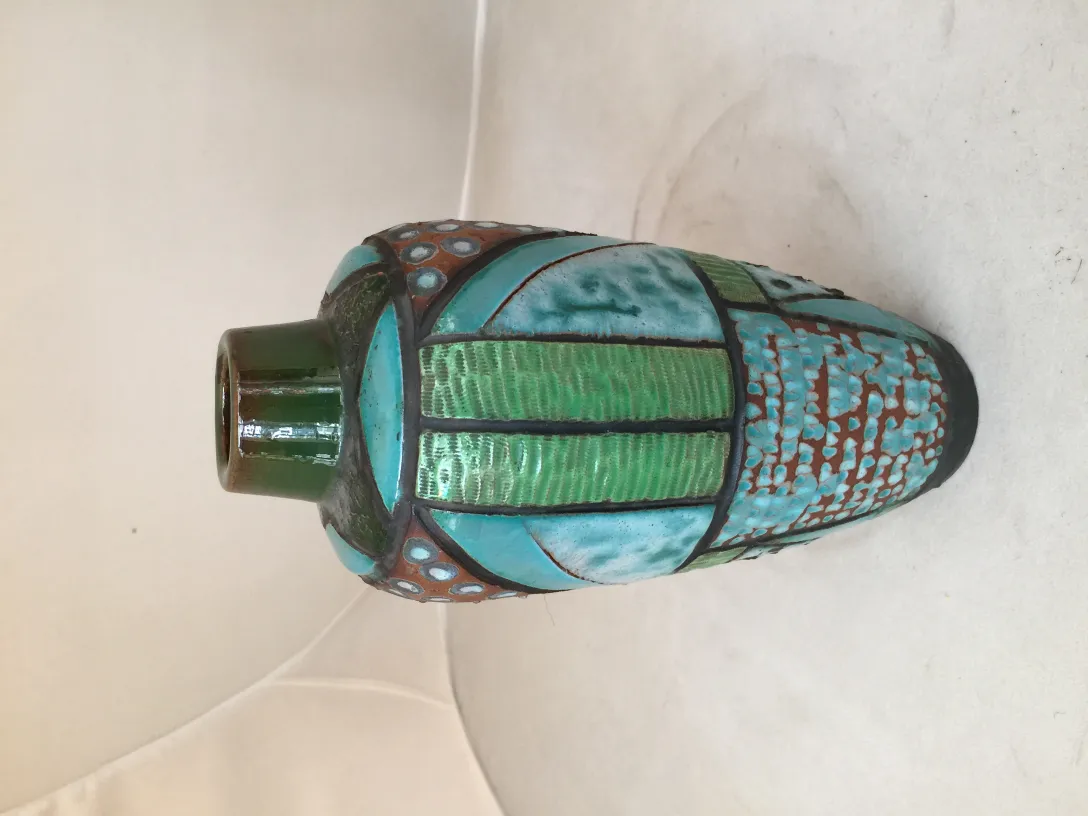 Antica ceramica decorativa in tonalità verdi e blu, con forme distintive.