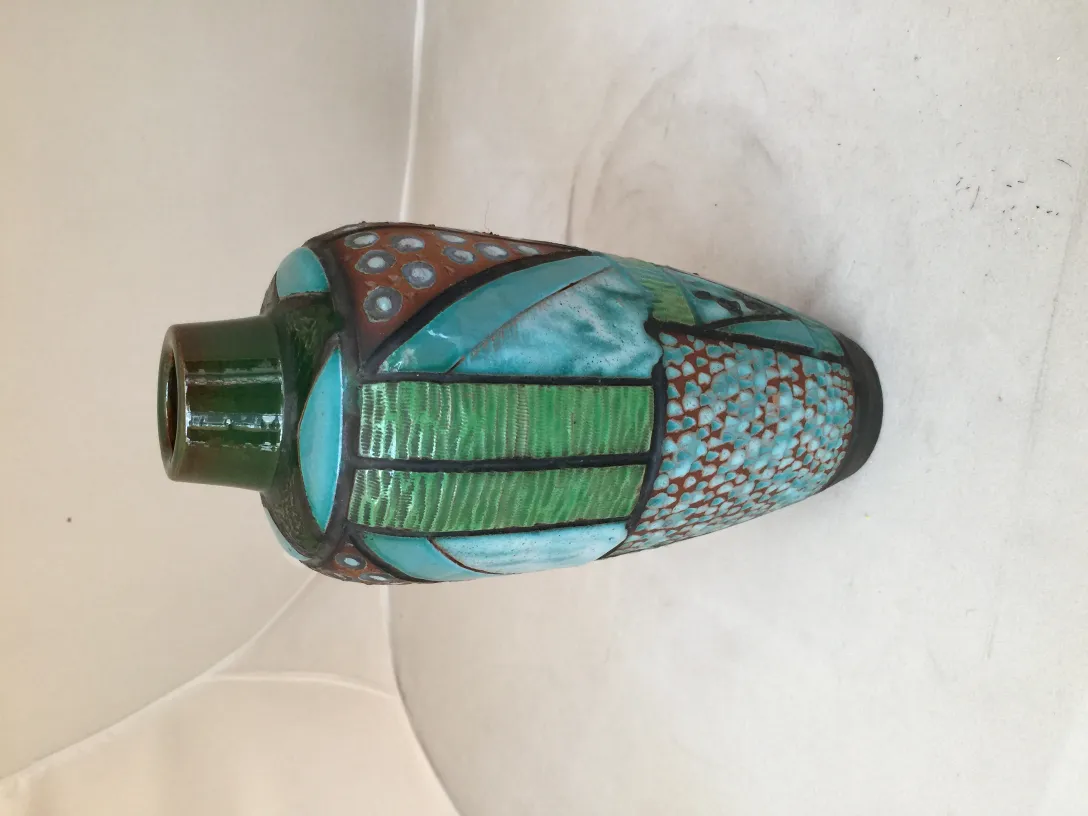 Jarrón antiguo de cerámica con colores vibrantes y diseño artístico.