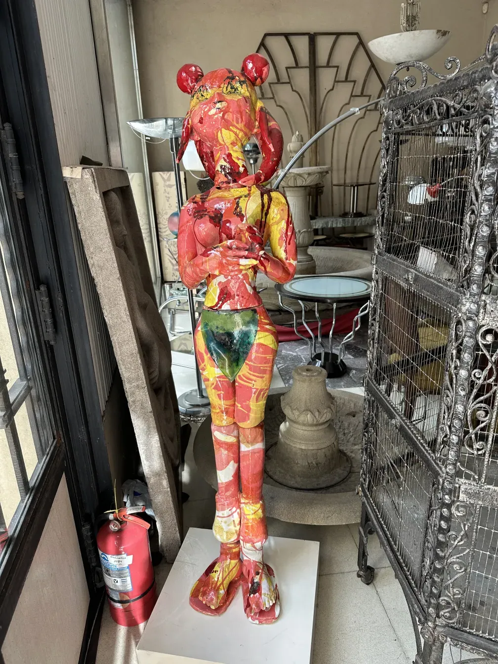 Antike keramische Skulptur in lebhaften Farben, mit dekorativem Hintergrund.