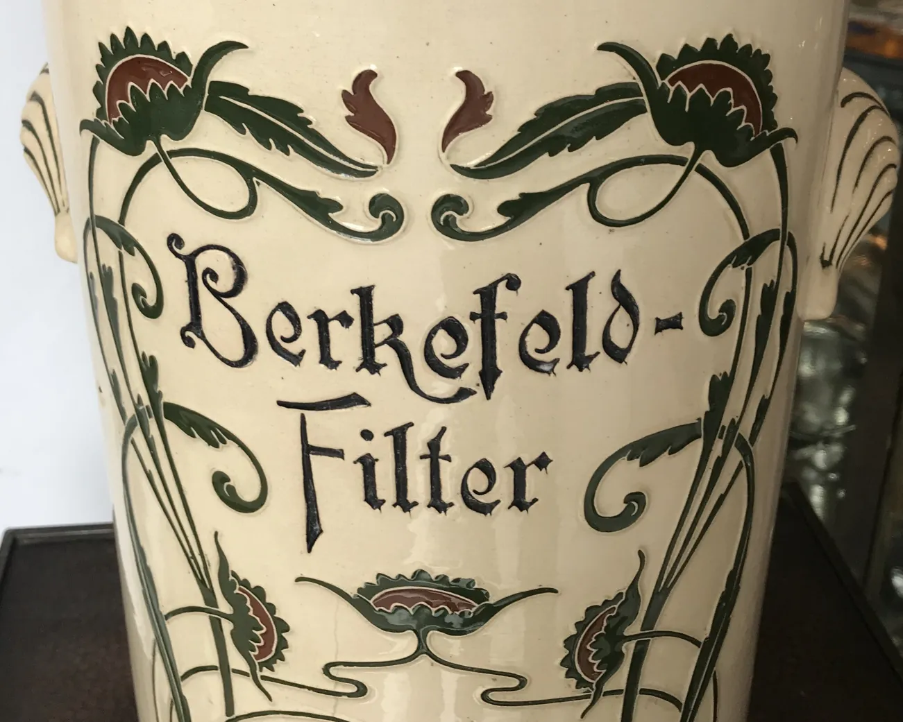 antik keramikvase mit floralem dekoration in grün und braun, mit text markiert