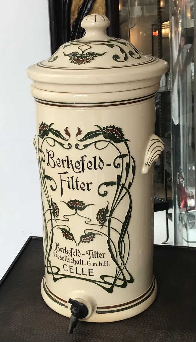 Alte Berkefeld-Keramik mit Blumendesign und Wasserhahn