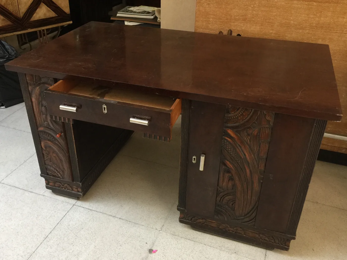 escritorio antiguo con un cajón y detalles decorativos