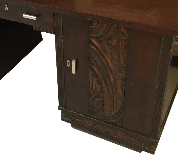 View of an antique desk with elaborate details and an elegant setting.