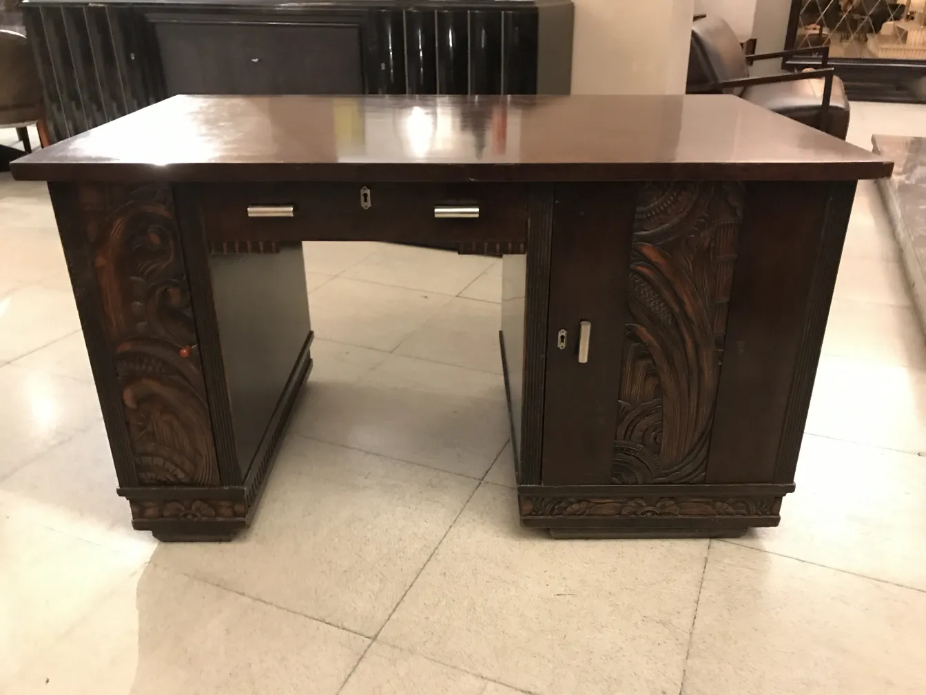 Escritorio antigo com detalhes esculpidos, ambiente elegante.