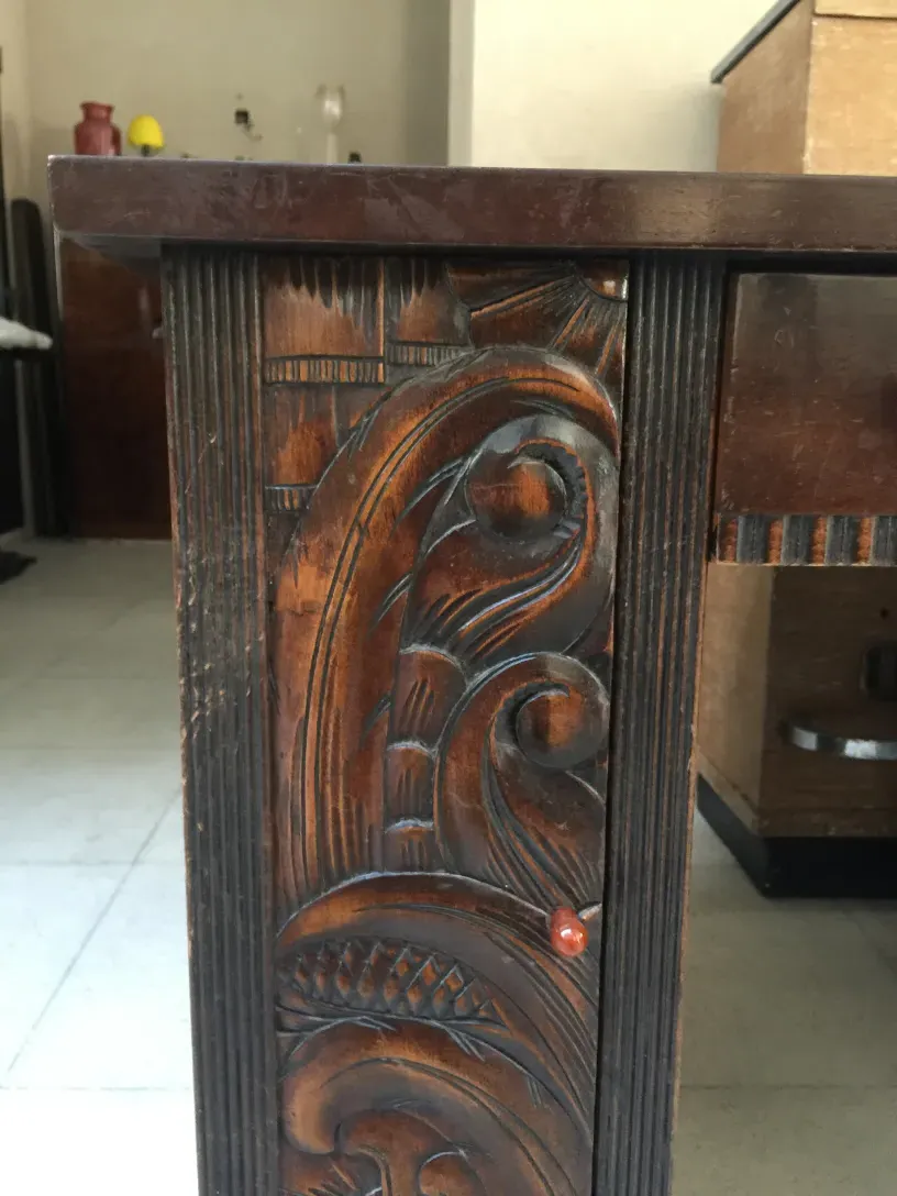 Antiker Holztisch mit kunstvollen Reliefdetails, warme Atmosphäre.