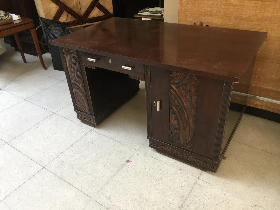 antique desk featuring intricate carvings in a cozy setting