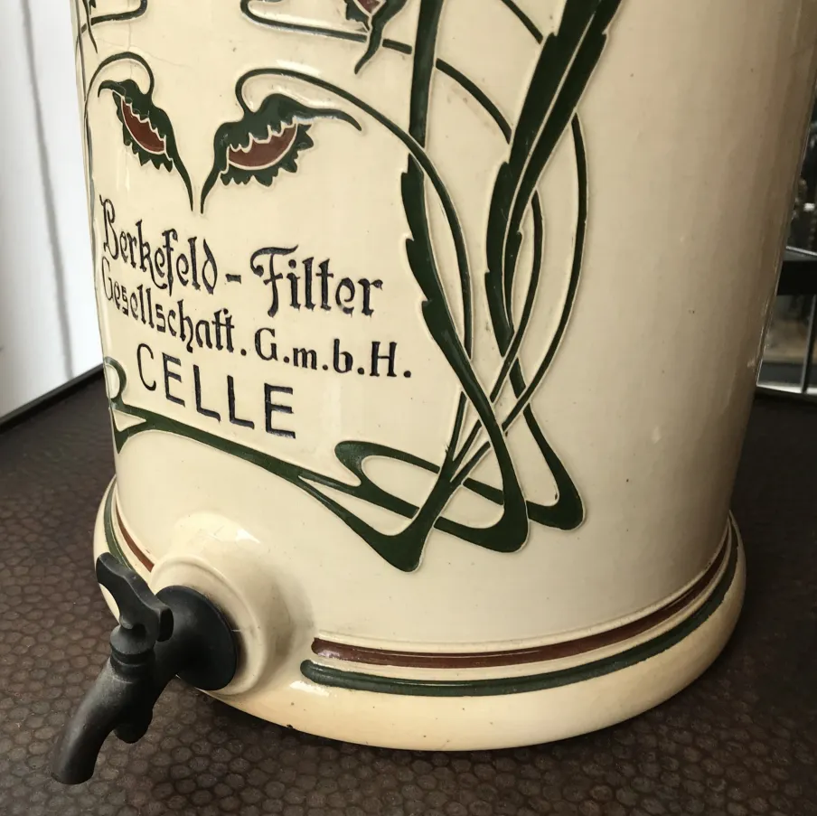 Antike Keramik mit floralem Design und Wasserhahn, helle Farbe