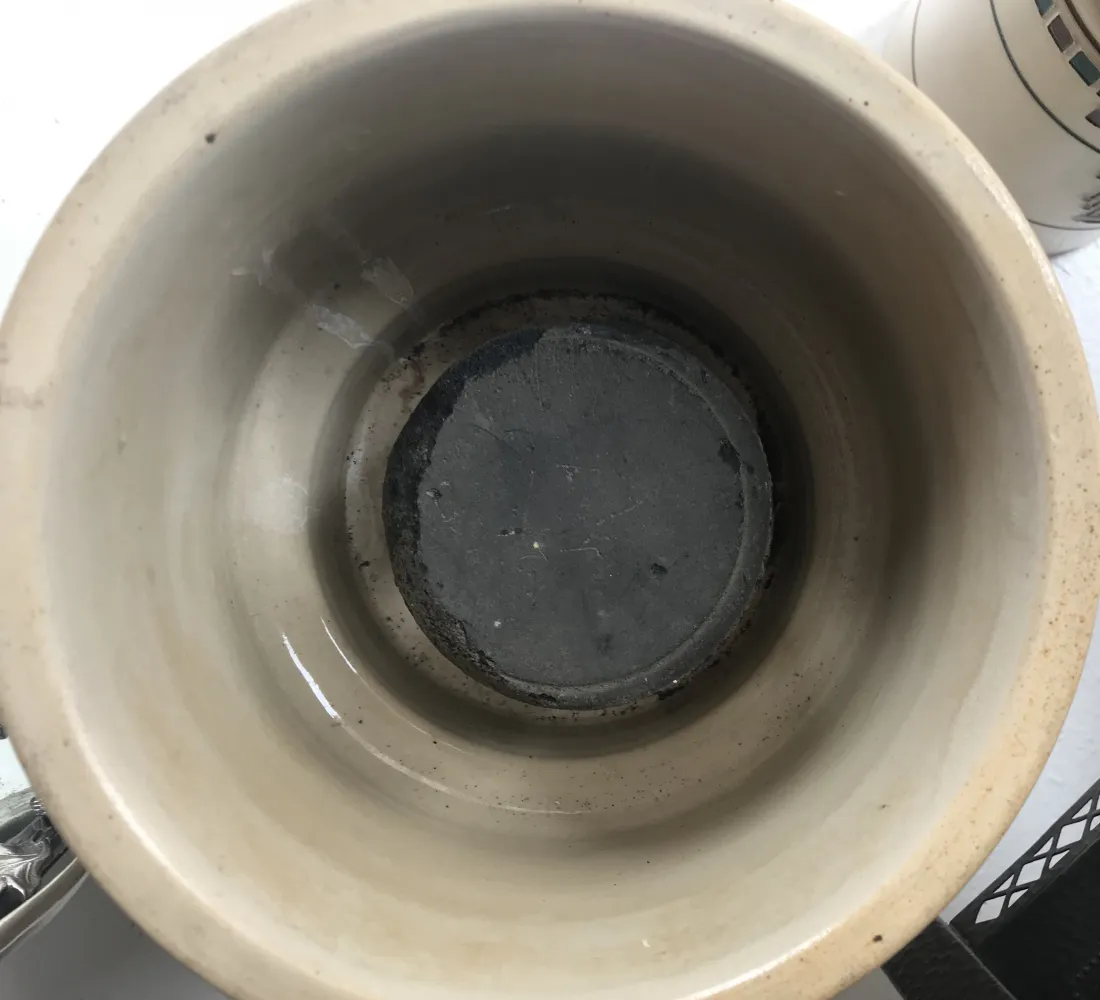 古い軽い色の陶器の鉢と暗い内装、明るい雰囲気。