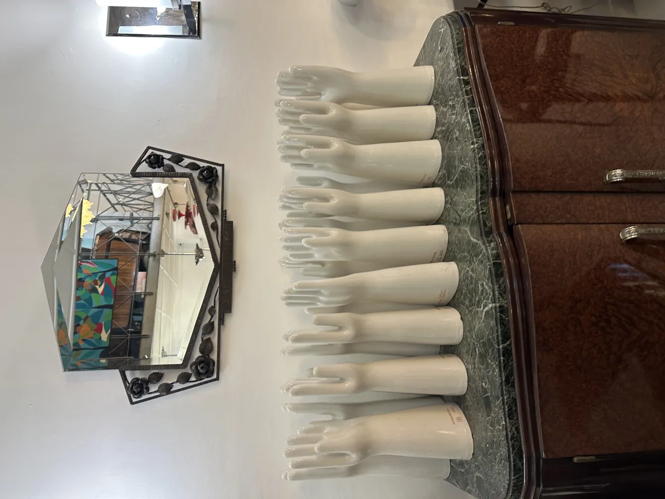 Decorative white ceramic hands displayed on an antique shelf
