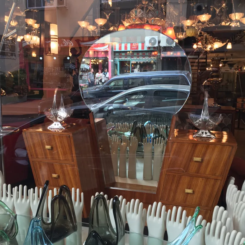 cerámica antigua en vitrina con manos decorativas y muebles