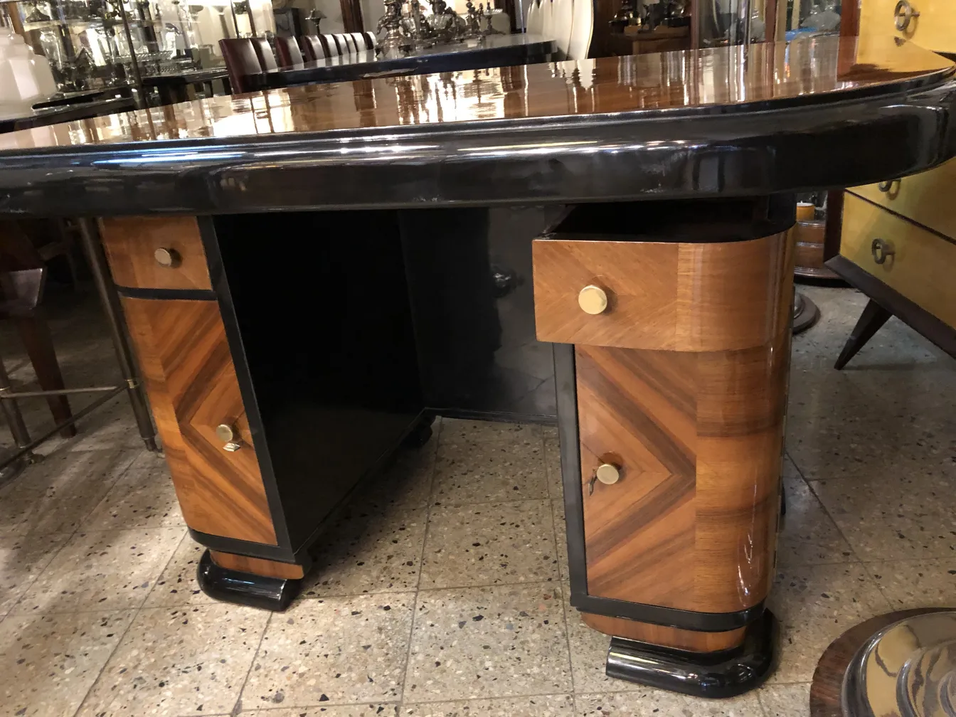 Bureau ancien au design élégant, avec des tiroirs et des accents brillants.