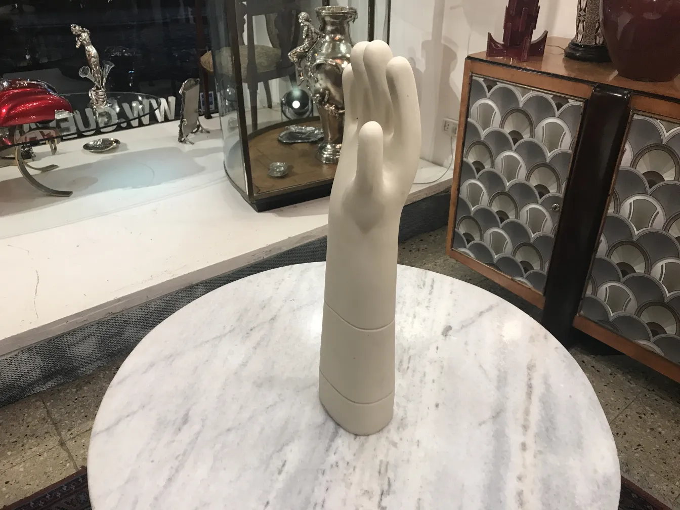 white ceramic hand on marble surface, antique decor
