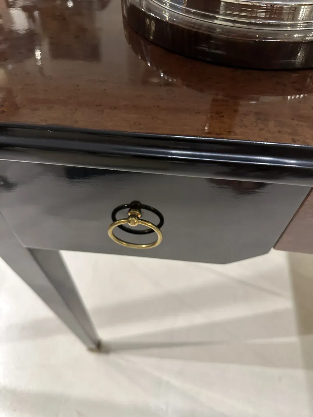 Escritorio antigo com acabamento decorativo dourado e puxador elegante.