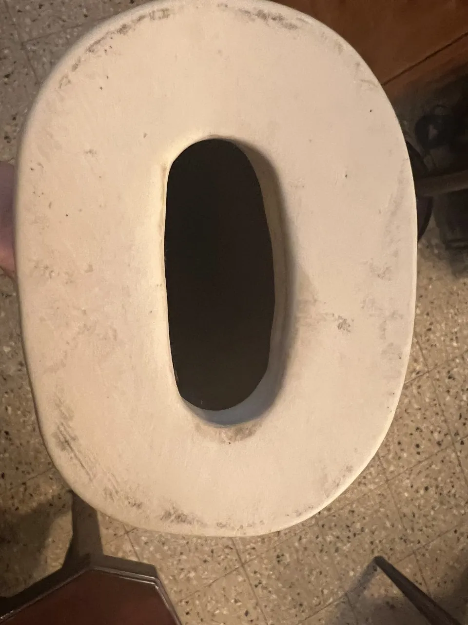 Scultura in ceramica antica di forma ovale con dettagli sottili.