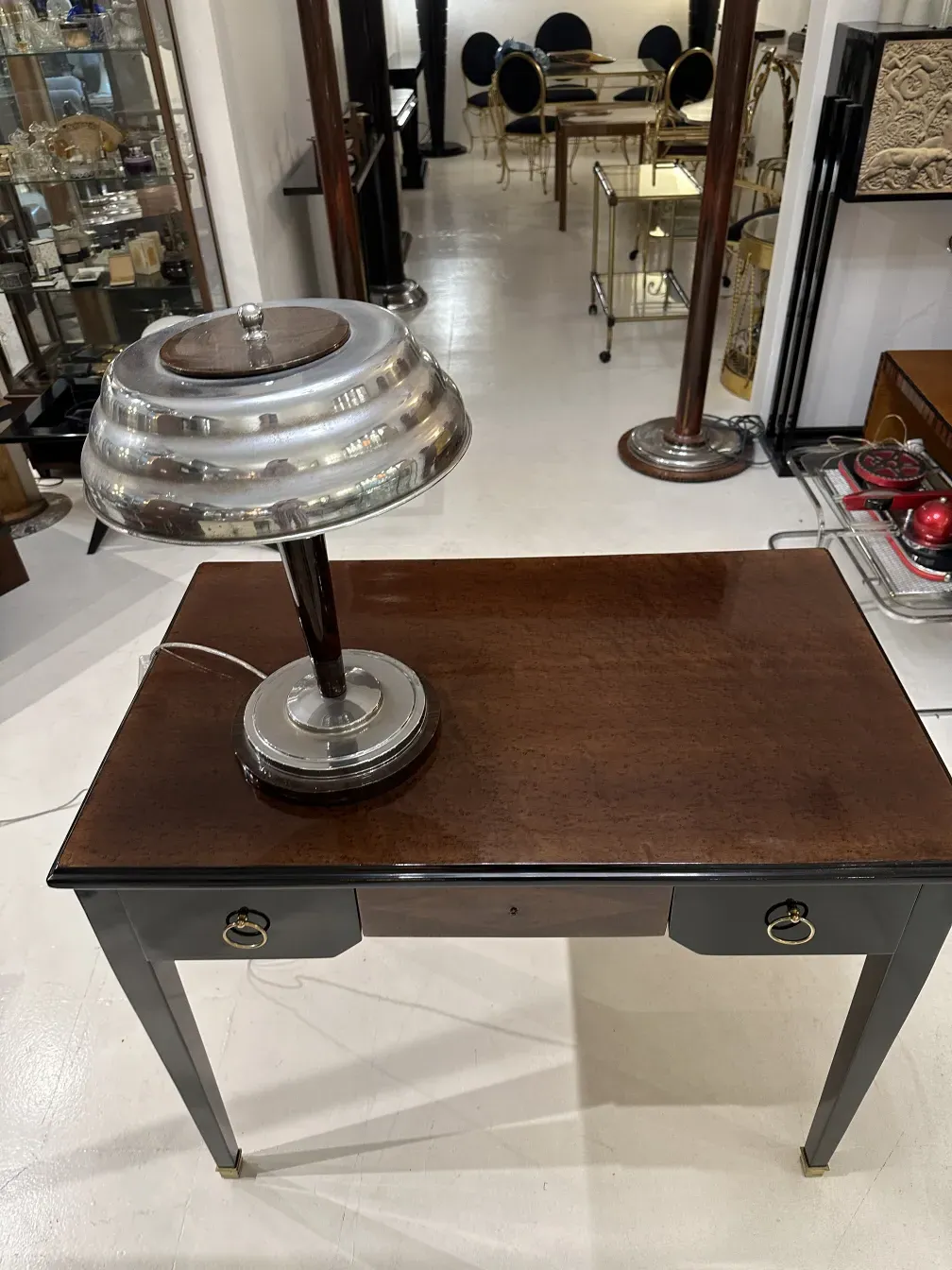 Bureau ancien avec lampe argentée, style élégant dans un cadre classique.