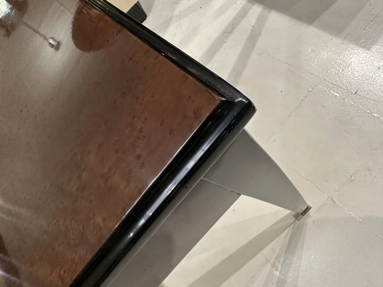 Vista de un escritorio antiguo con un acabado brillante y patas visibles